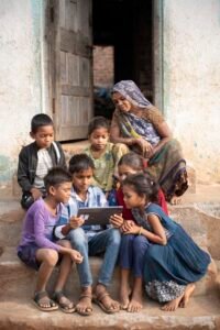 Korku tribal children in Madhya Pradesh watching science videos on a MediaTek powered tablet while their grandmother curiously enjoys the learning experience with them.