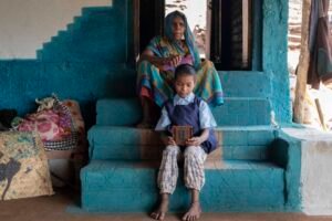 A grandmother from the Korku tribe in Madhya Pradesh helping her granddaughter get ready for school.