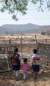 Two siblings from the Korku tribe in Madhya Pradesh walking to school while their younger brother accompanies them to the main road.